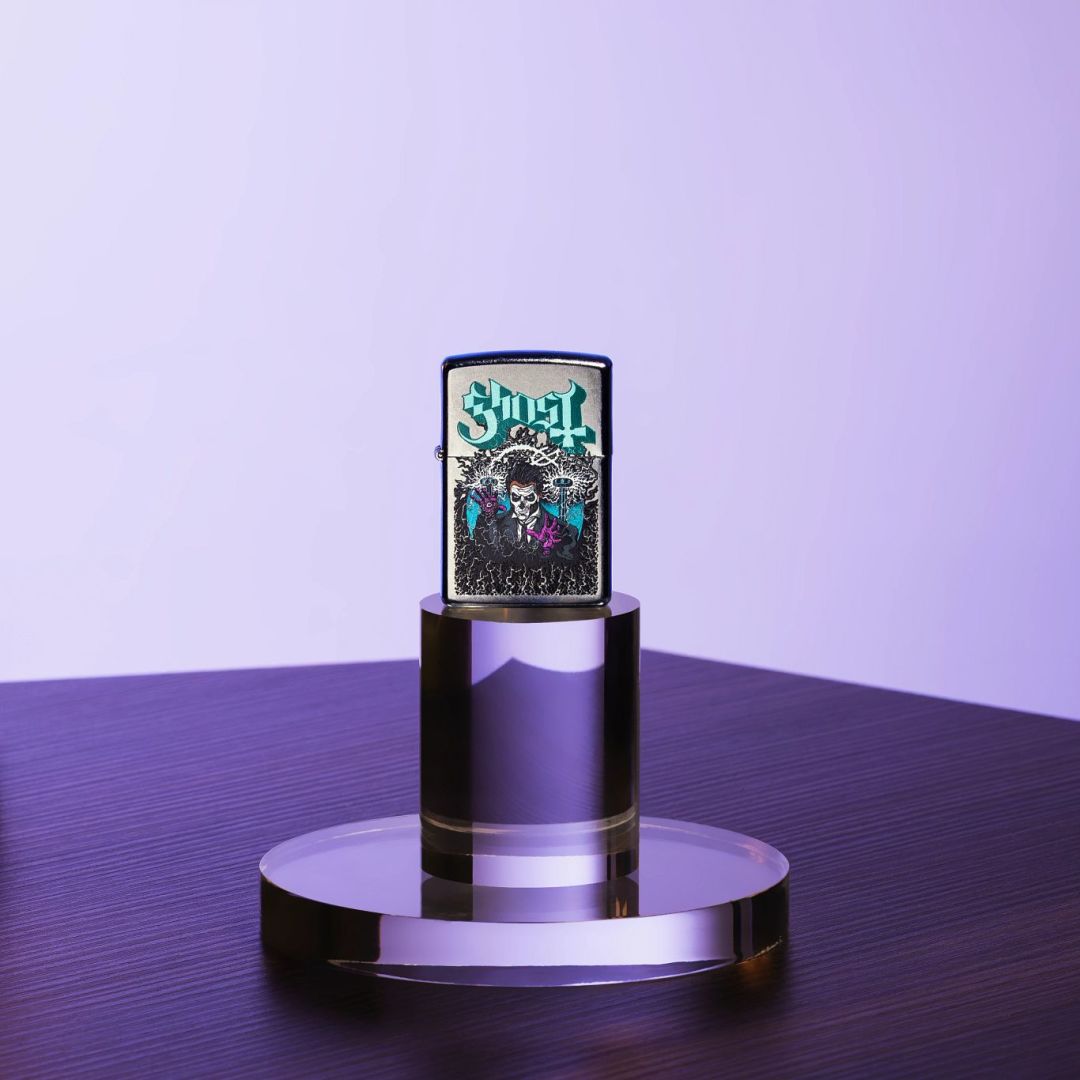 Lifestyle image of Zippo Ghost Papa III Design Classic Street Chrome Windproof Lighter standing on a clear stand on a table showing the front of the lighter with a purple-colored background.
