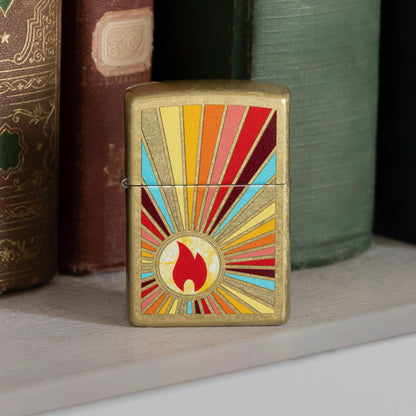 Lifestyle image of Zippo Beaming Flame Design Street Brass Windproof Lighter standing on a bookshelf in front of several books showing the front of the lighter. 

