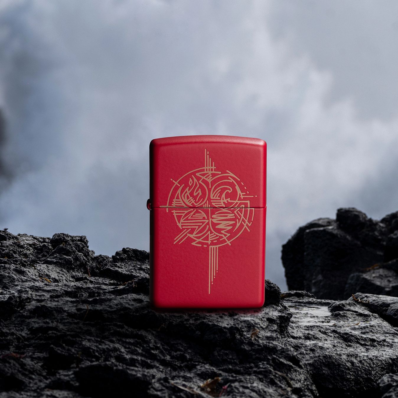 Lifestyle image of Zippo Elements Design Red Matte Windproof Lighter standing on a rough rock surface with a foggy background.

