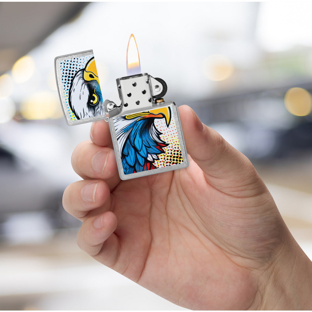 Zippo Pop Art Eagle Design Street Chrome Windproof Lighter lit in hand.