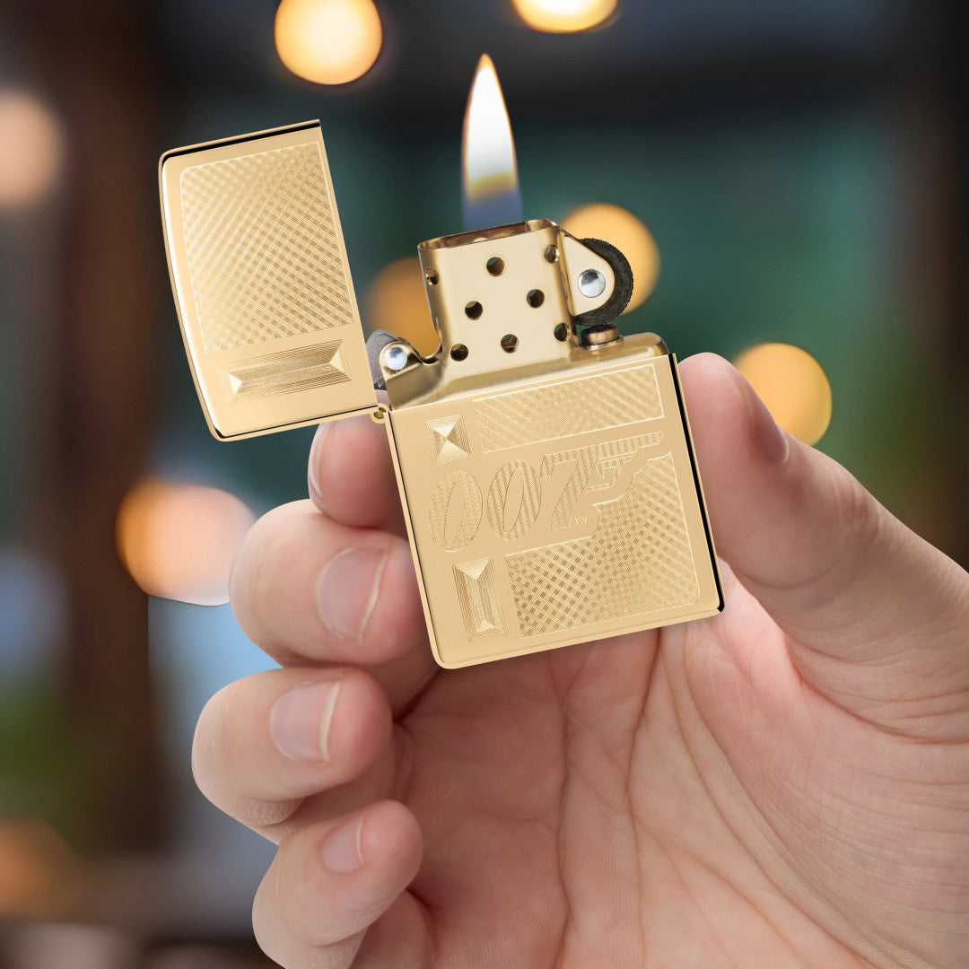Zippo James Bond 007™ Gingham Design High Polish Brass Windproof Lighter lit in hand.