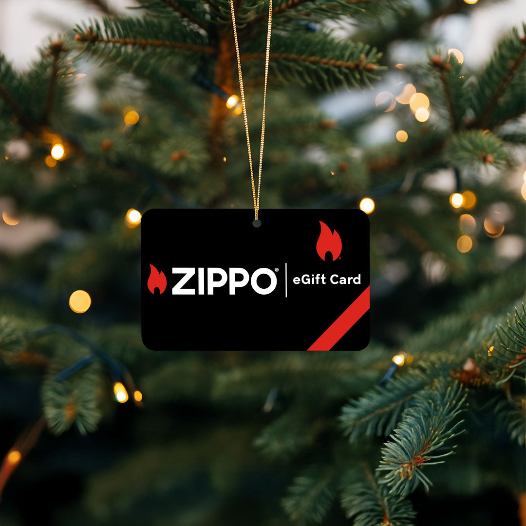 Zippo eGift card hanging on a Christmas tree with blurred lights in the background