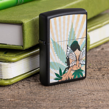 Lifestyle image of Zippo Cannabis Fairy Design Black Matte Windproof Lighter standing in front of two green notebooks stacked on each other.