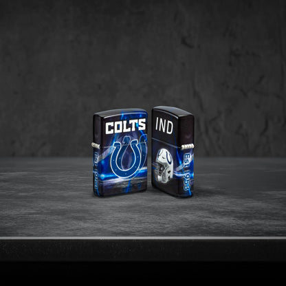 Lifestyle image of two Zippo NFL Indianapolis Colts 540 Matte Windproof Lighters, one showing the front of the lighter and the other showing the back, standing on a dark grey surface.