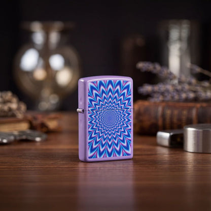 Lifestyle image of Zippo Lavender Illusion Design Smoky Lavender Windproof Lighter standing on a wooden table next to books and table decor showing the front and hinge side of the lighter with an out of focus background.

