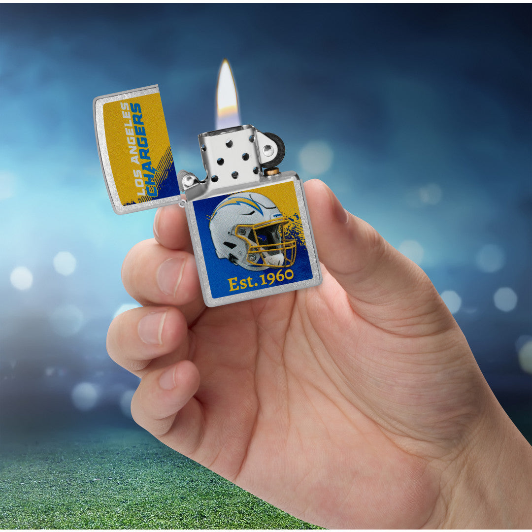 Zippo NFL Los Angeles Chargers Helmet Design Street Chrome Windproof Lighter lit in hand.