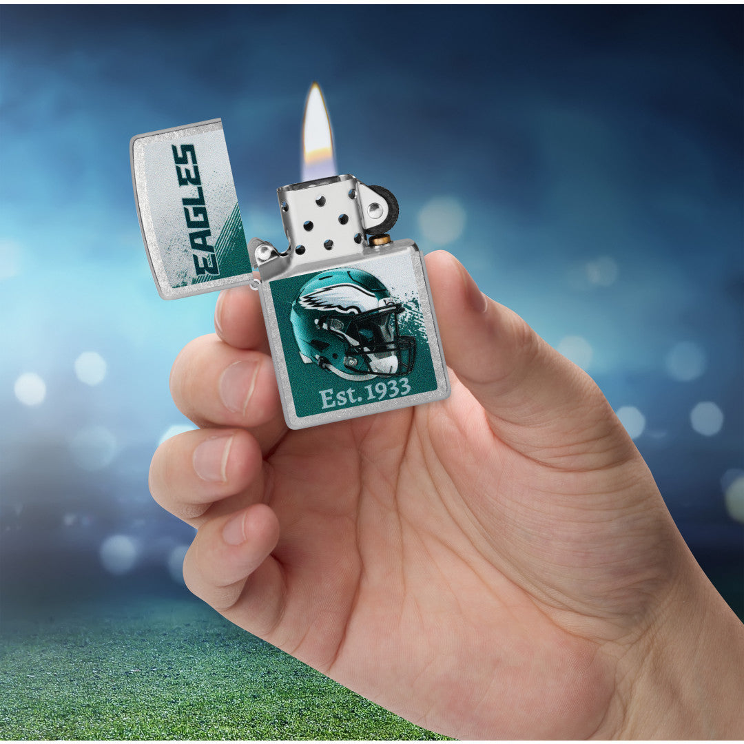 Zippo NFL Philadelphia Eagles Helmet Design Street Chrome Windproof Lighter lit in hand.
