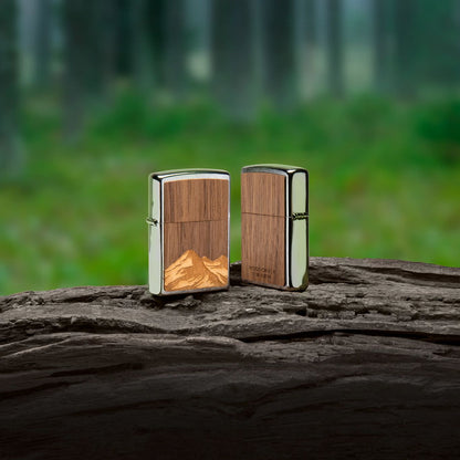 Lifestyle image of WOODCHUCK USA Mountains Brushed Chrome Windproof Lighter, standing in a forrest.