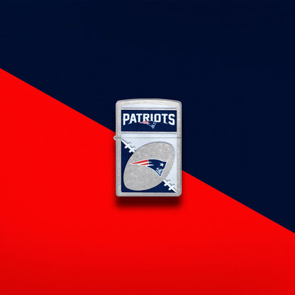 Lifestyle image of Zippo NFL New England Patriots Street Chrome Windproof Lighter set on a red and dark blue background.