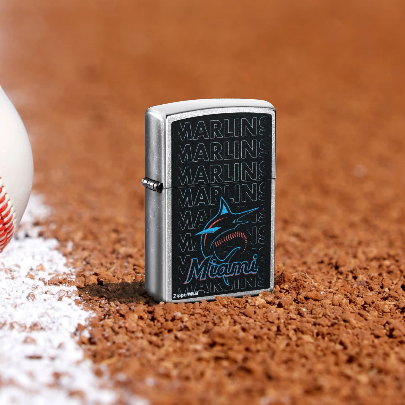 Lifestyle image of Zippo MLB® Miami Marlins Street Chrome Windproof Lighter standing in the dirt on a baseball field.