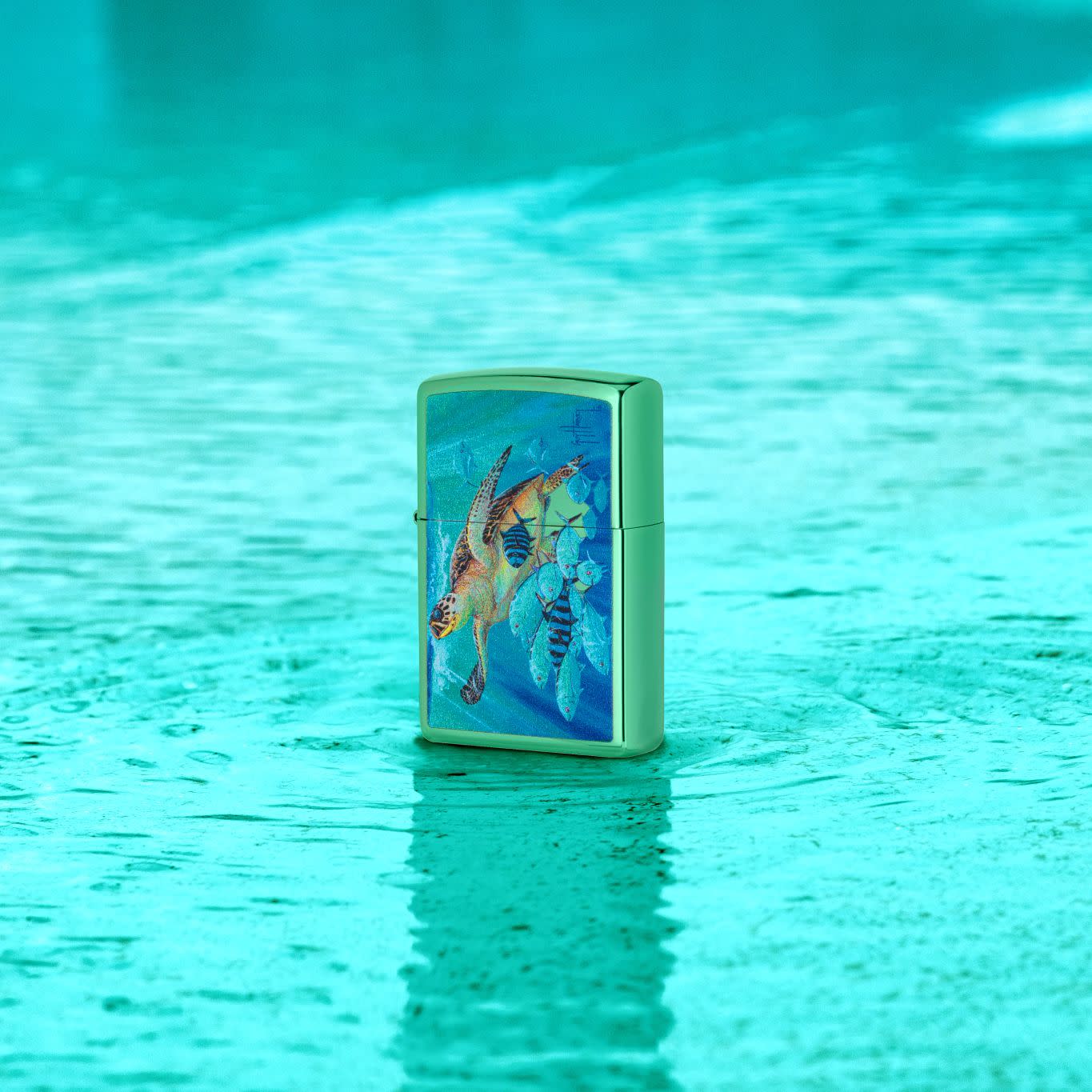 Lifestyle image of Zippo Guy Harvey Hawksbill Caravan High Polish Green Windproof Lighter standing in a shallow pool of water with an aqua color.