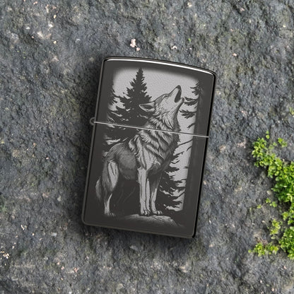 Lifestyle image of Zippo Howling Wolf Design High Polish Black Windproof Lighter lying on a flat rocky surface showing the front of the lighter. 

