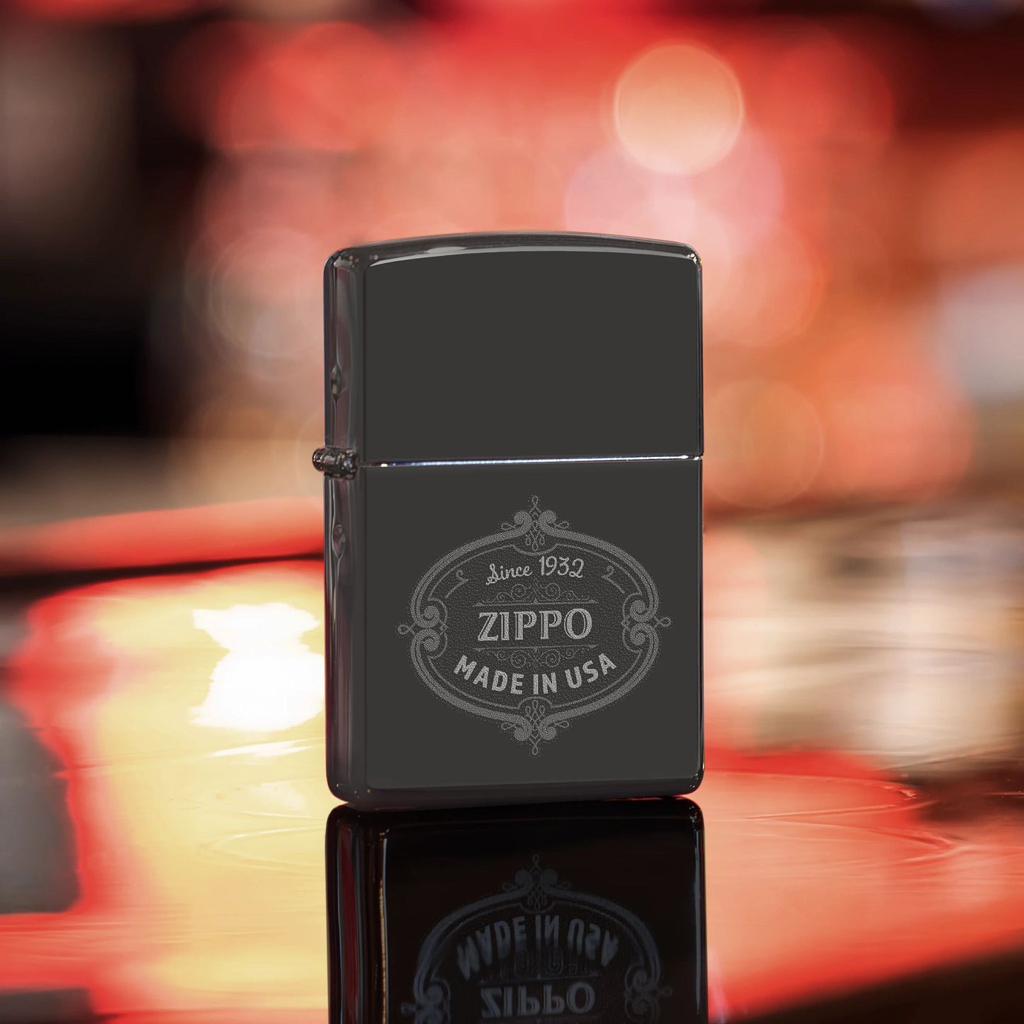 Lifestyle image of Zippo Plaque Design High Polish Black Windproof Lighter standing on a bar showing the front of the lighter. 

