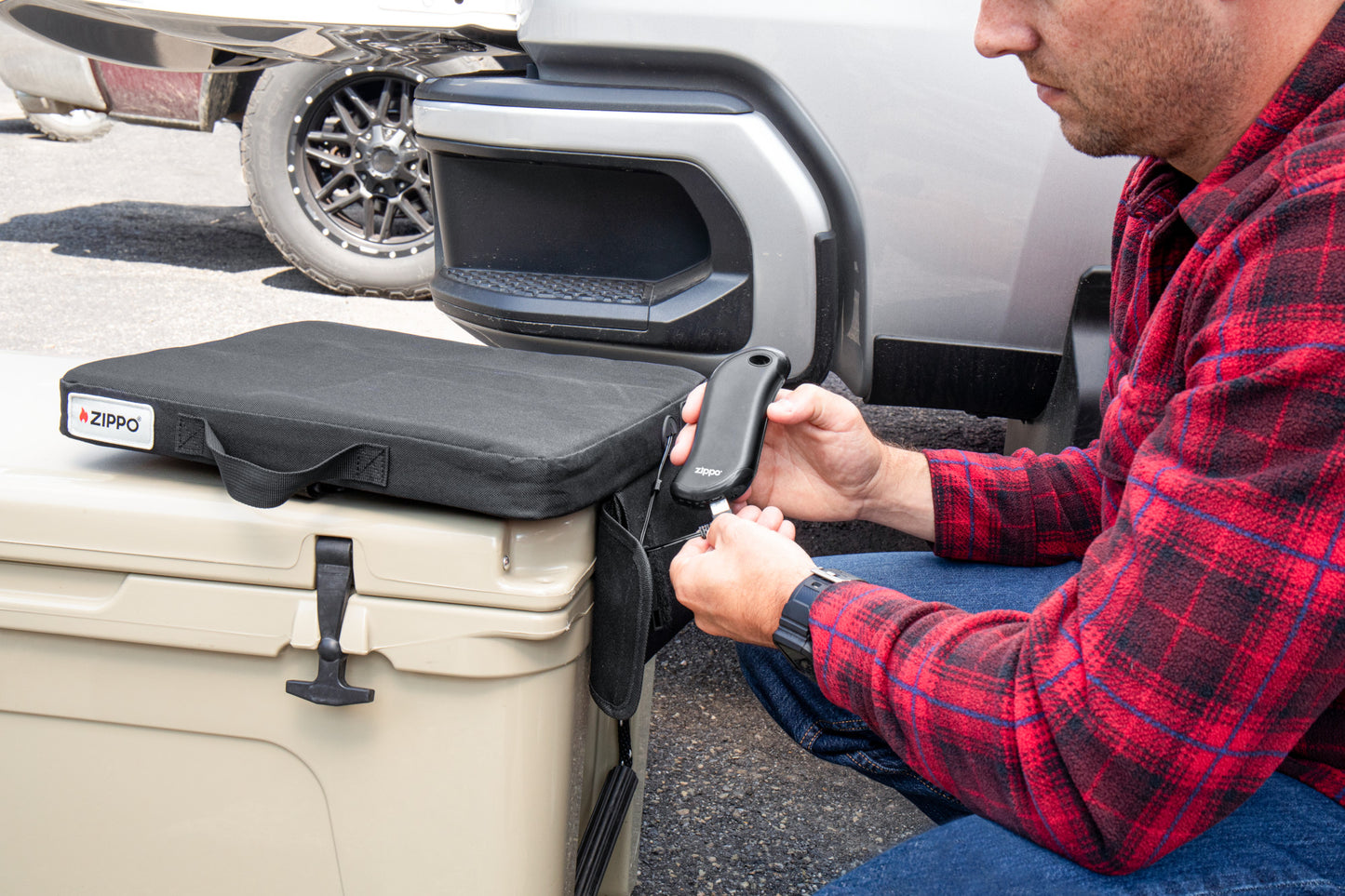 Lifestyle image of Zippo Heated Seat - Single showing a man plugging in the HeatBank® 9s (included).