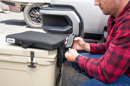 Lifestyle image of Zippo Heated Seat - Single showing a man plugging in the HeatBank® 9s (included).