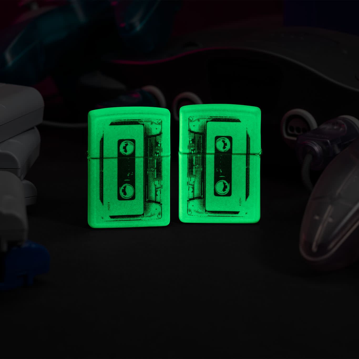 Lifestyle image of two Zippo Cassette Tape Design Glow in the Dark Windproof Lighters glowing in the dark.