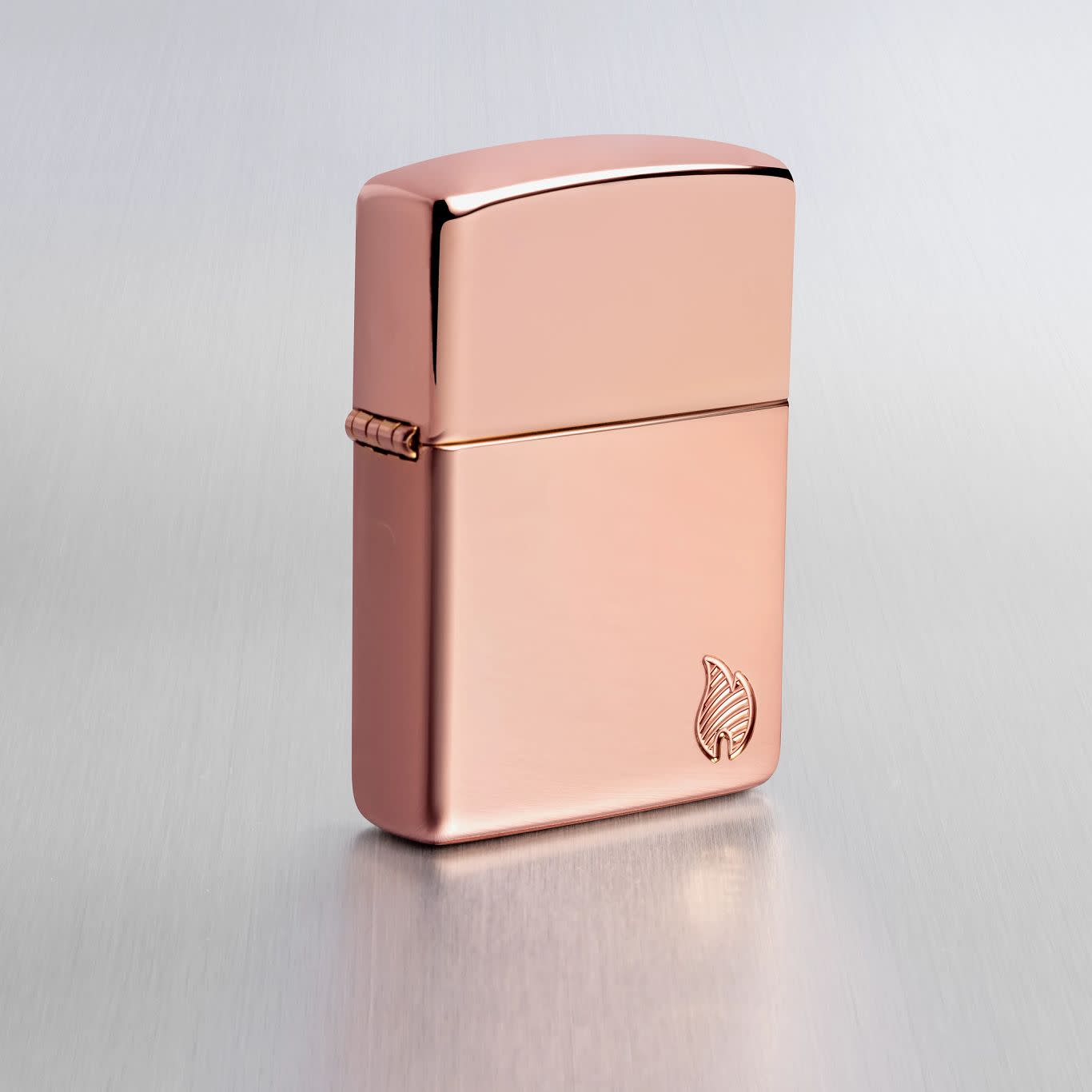 Lifestyle image of Zippo Armor® Series Flame High Polish Rose Gold Windproof Lighter on a light gray background.