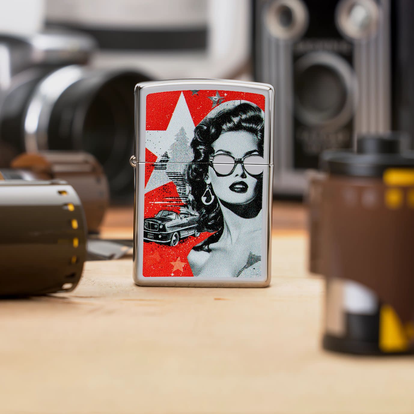 Lifestyle image of Zippo Glam Glasses Design High Polish Chrome Windproof Lighter standing on a table with rolls of film.