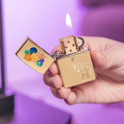 Lifestyle image of Zippo Liftoff Design High Polish Brass Windproof Lighter lit in hand in front of a light purple background.