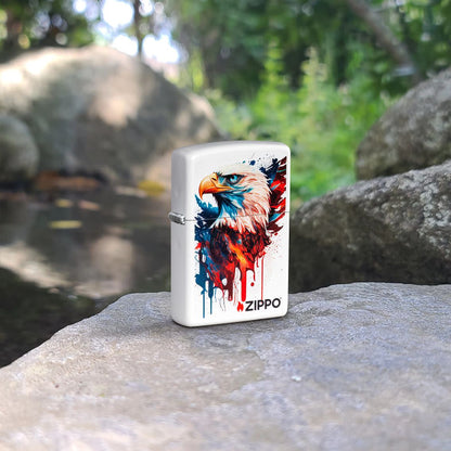 Lifestyle image of Zippo Painted Eagle Design White Matte Windproof Lighter standing on a rock with more rocks and greenery in the background.