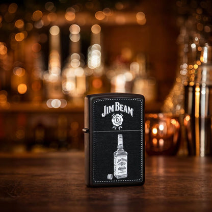 Lifestyle image of Zippo Jim Beam® Bottle Design Black Matte Windproof Lighter standing showing the front of the lighter with an out of focus bar as the background.

