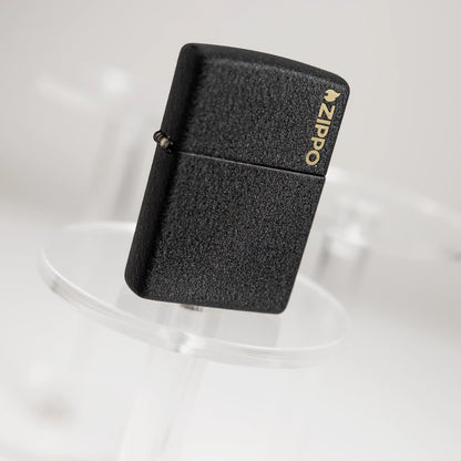 Lifestyle image of Zippo Classic Black Crackle® Zippo Logo Windproof Lighter standing on a clear pedestal with the image at an angle.