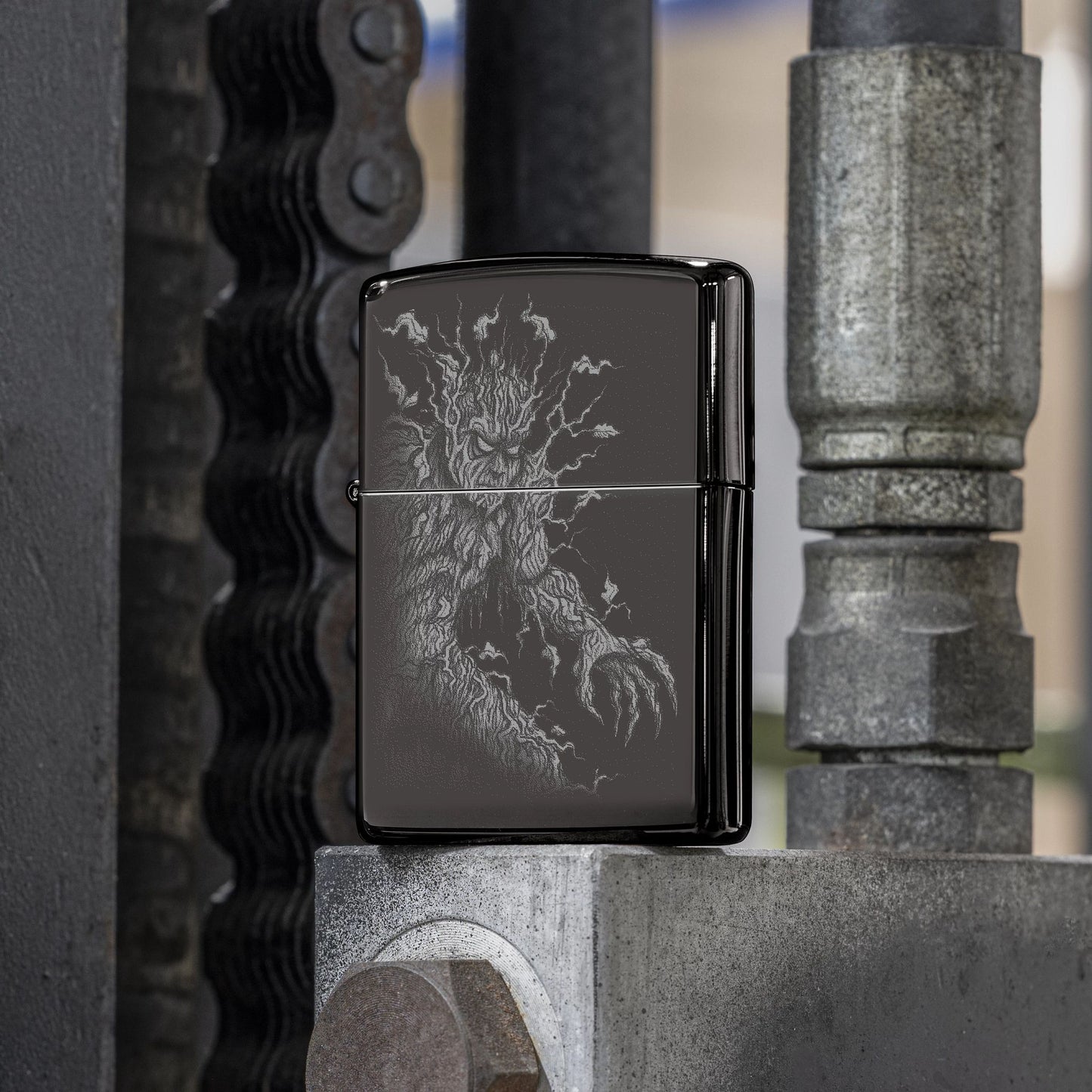 Lifestyle image of Zippo Root of All Evil Design High Polish Black Windproof Lighter standing on a metal surface in a workshop while showing the front of the lighter. 

