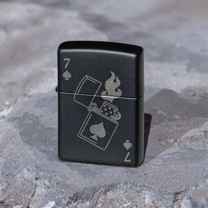 Lifestyle image of Zippo Lucky 7 Design Black Matte With Chrome Windproof Lighter standing on a stone surface showing the front of the lighter. 

