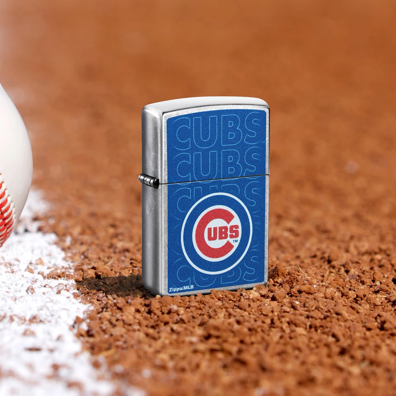 Lifestyle image of Zippo MLB® Chicago Cubs Street Chrome Windproof Lighter standing in the dirt on a baseball field.