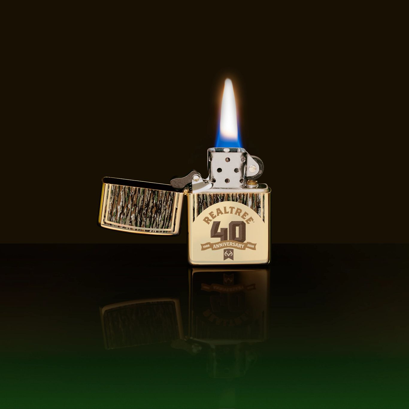 Lifestyle image of Zippo Realtree® 40th Anniversary Design Champagne Windproof Lighter showing the front of the lighter with its lid open and lit with a black and green ombre background. 

