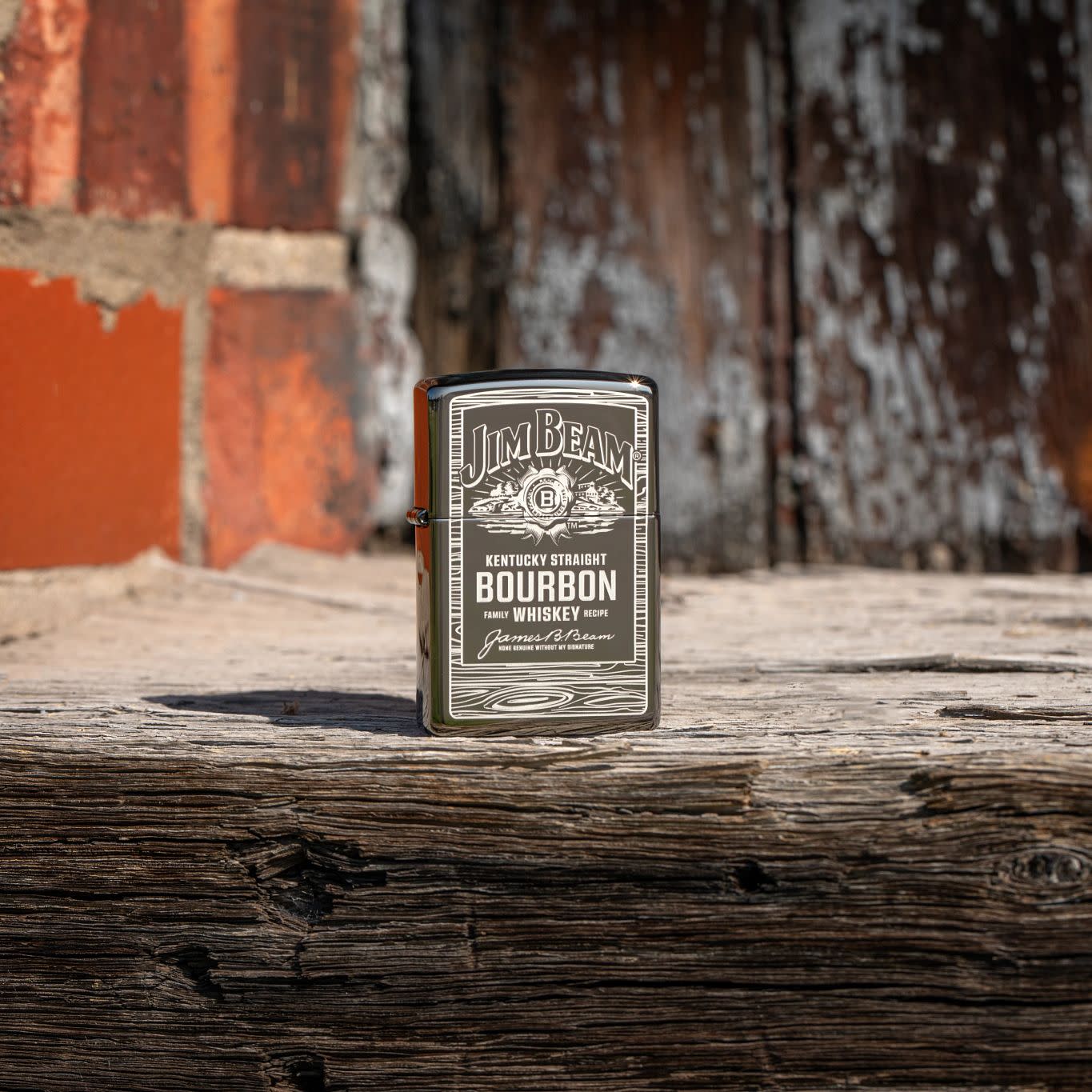 Lifestyle image of Zippo Jim Beam Black Ice Windproof Lighter standing on wood with a brick wall behind it.