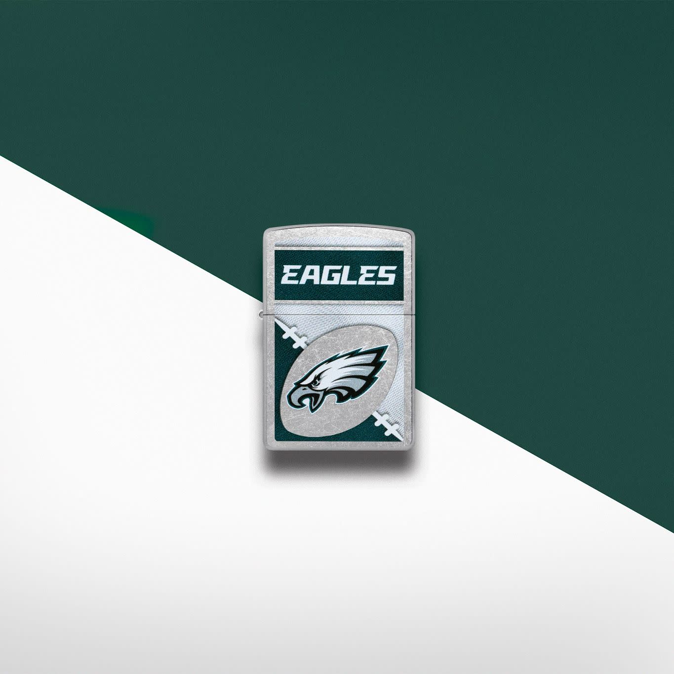 Lifestyle image of Zippo NFL Philadelphia Eagles Street Chrome Windproof Lighter set on a silver and green background.