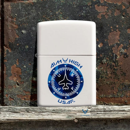 Lifestyle image of Zippo U.S. Air Force™ Aim High Design White Matte Windproof Lighter standing on a piece of wood showing the front of the lighter with a rusty painted metal door as the background. 

