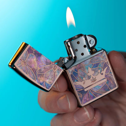 Lifestyle image of Zippo Queen of Bud Opal Crown Design High Polish Rose Gold Windproof Lighter lit in hand showing the front of the lighter with a light blue background.