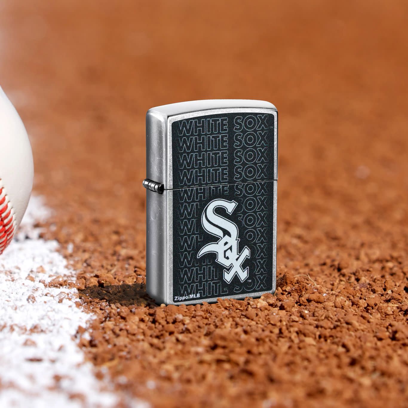 Lifestyle image of Zippo MLB® Chicago White Sox Street Chrome Windproof Lighter standing in the dirt on a baseball field.