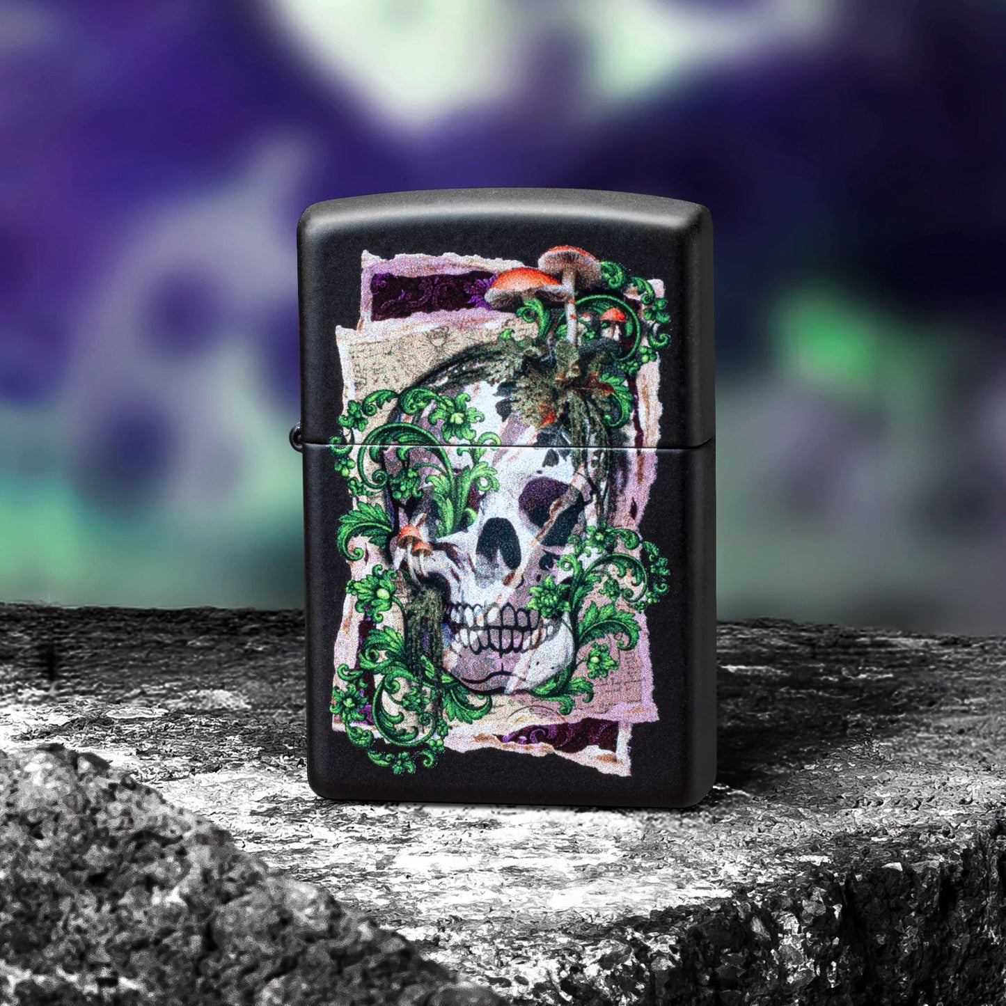 Lifestyle image of Zippo Skull Collage Design Black Matte Windproof Lighter standing on a dark rock in front of a wall covered in purple and green graffiti showing the front of the lighter. 

