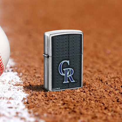 Lifestyle image of Zippo MLB® Colorado Rockies Street Chrome Windproof Lighter standing in the dirt on a baseball field.