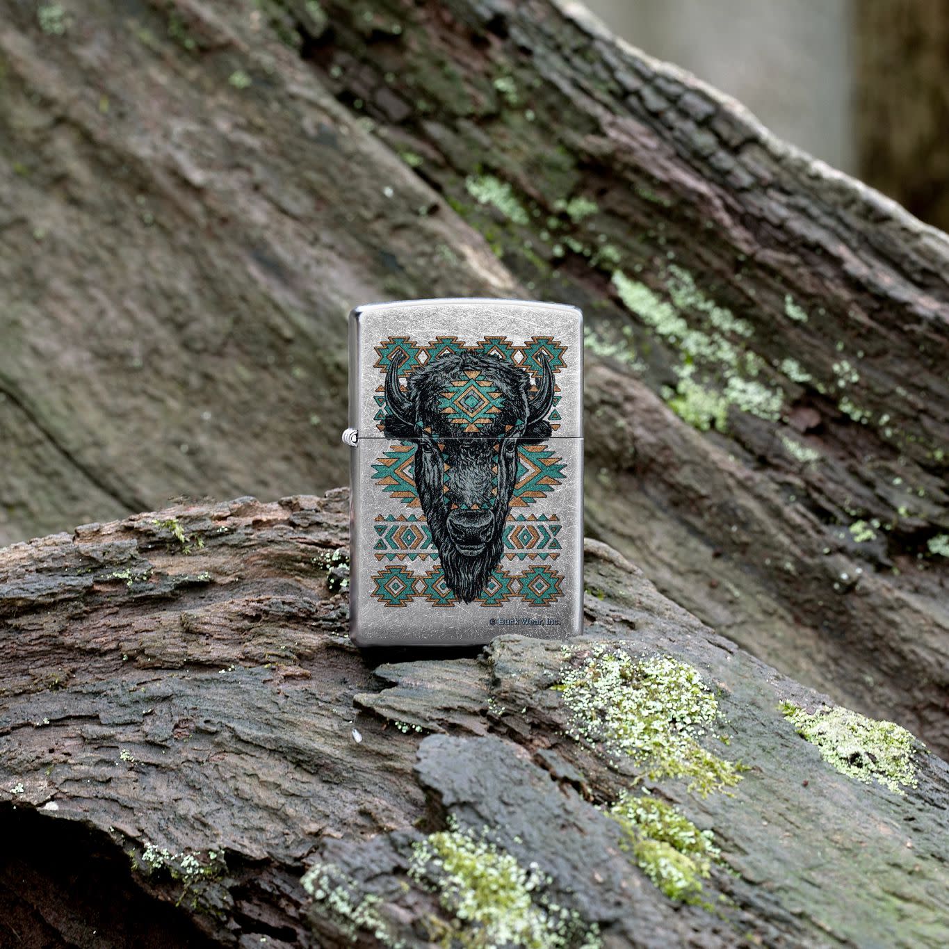 Lifestyle image of Zippo Buck Wear™ Southwest Bison Design Street Chrome Windproof Lighter standing on a fallen and decayed log.