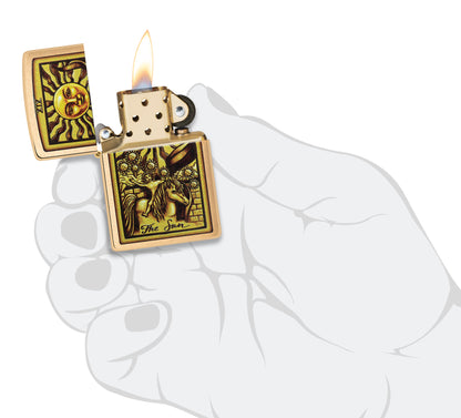 Zippo Tarot Card Brushed Brass Windproof Lighter lit in hand.