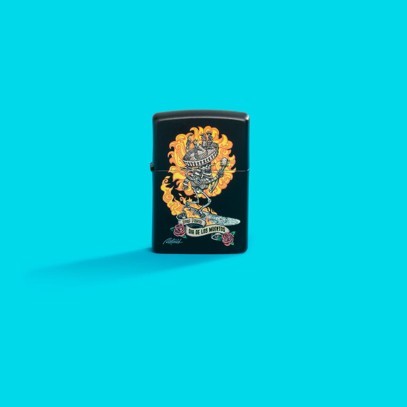 Lifestyle image of Zippo Rick Rietveld Black Matte Windproof Lighter on an aqua blue background.