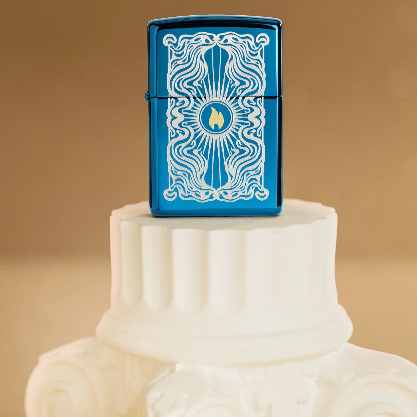 Lifestyle image of Zippo Fancy Flame Design High Polish Blue Windproof Lighter standing on a cream colored, grooved pedestal.