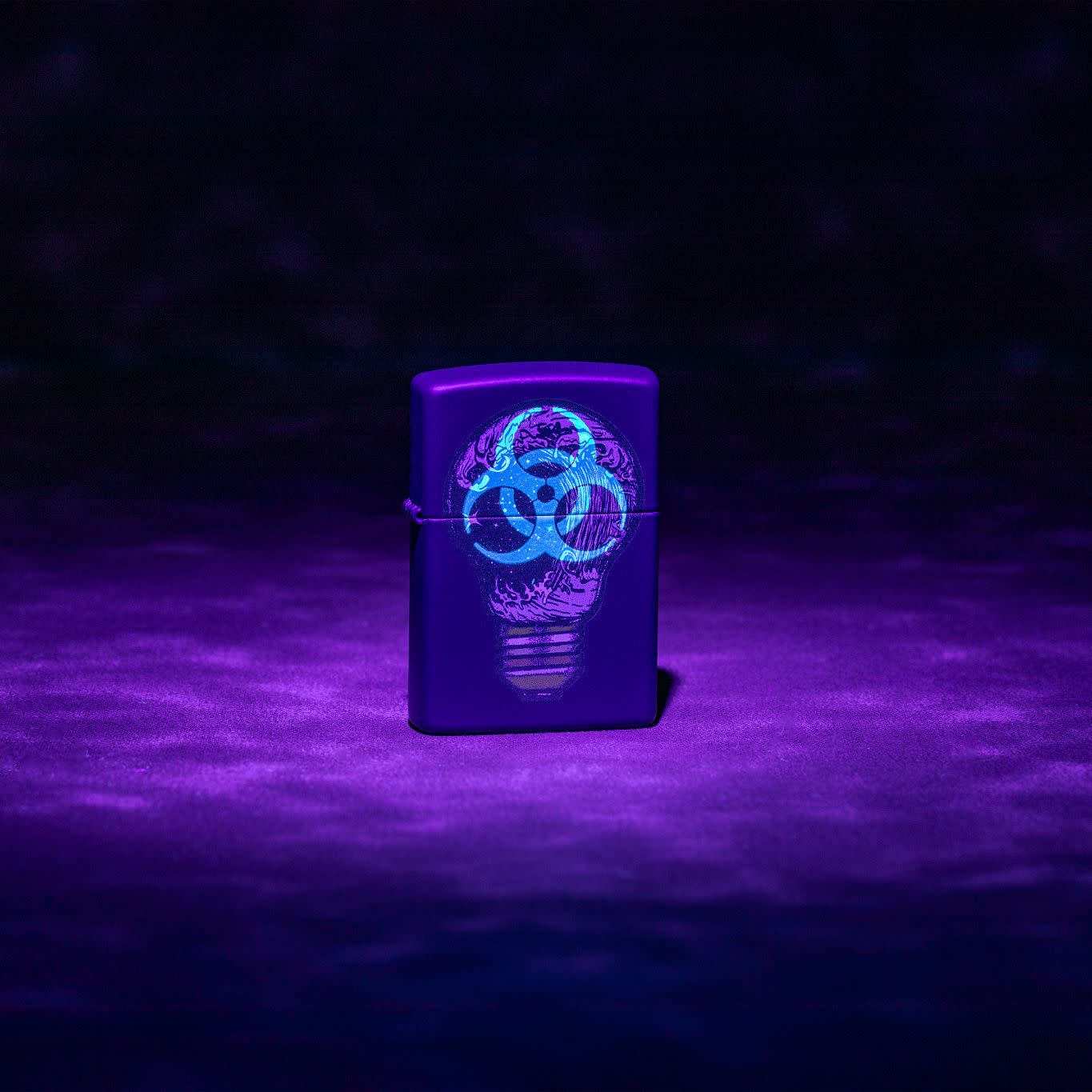 Lifestyle image of Zippo Black Light Toxic Waves Design Navy Matte Windproof Lighter glowing under a black light.