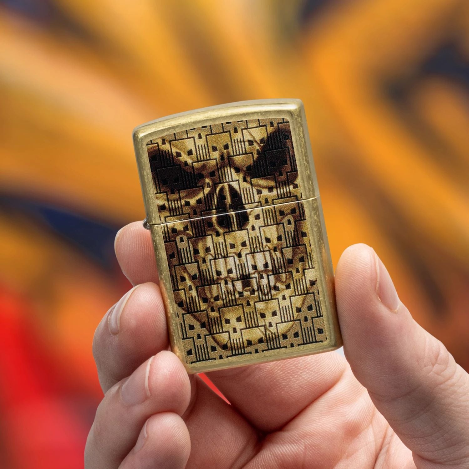 Lifestyle image of Zippo Skulls on Skulls Design Street Brass Windproof Lighter being held in hand while showing the front of the lighter with a yellow and red graffiti background. 


