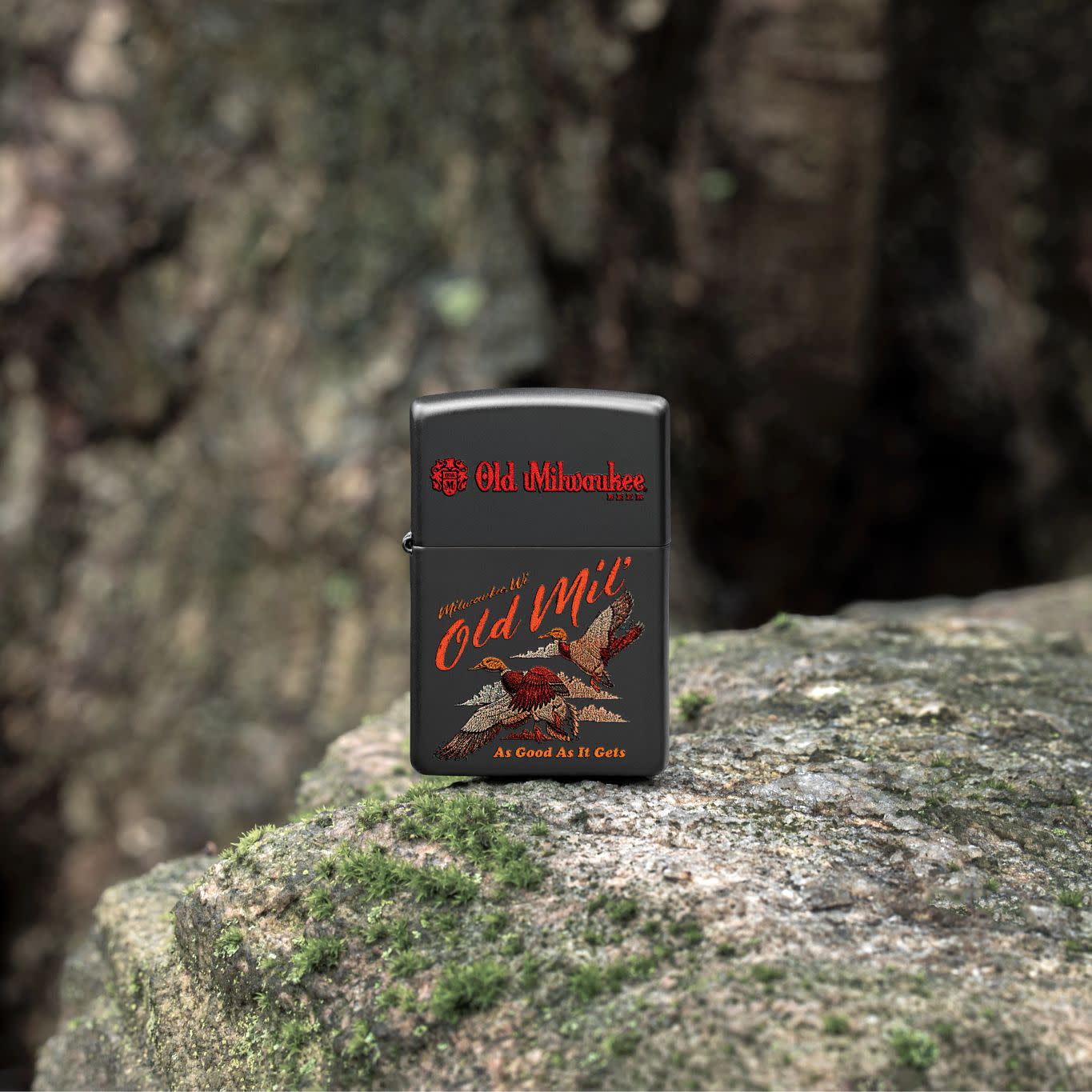 Lifestyle image of Zippo Old Milwaukee Duck Hunt Design Black Matte Windproof Lighter standing on a mossy rock.