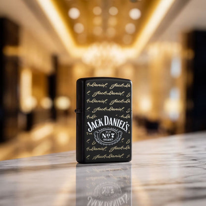 Lifestyle image of Zippo Jack Daniel's Signature Design Black Matte Windproof Lighter standing on a grey stone countertop showing the front of the lighter with an out of focus hotel lobby as the background. 

