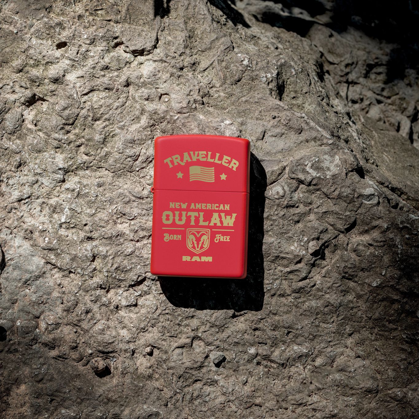 Lifestyle image of Zippo Ram Traveller Design Red Matte Windproof Lighter lying on a fossilized boulder.

