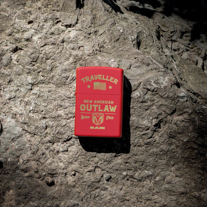 Lifestyle image of Zippo Ram Traveller Design Red Matte Windproof Lighter lying on a fossilized boulder.

