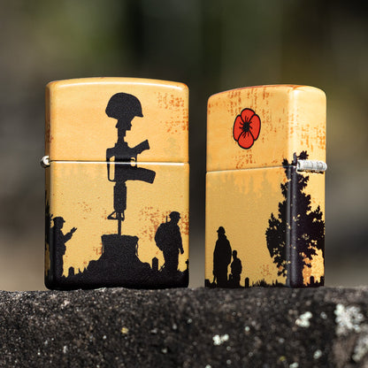 Lifestyle image of two Zippo 2025 Veterans Day Commemorative 540 Matte Windproof Lighters standing on a black rock, one lighter is showing the front of the design while the other shows the back and hinge side of the lighter. 

