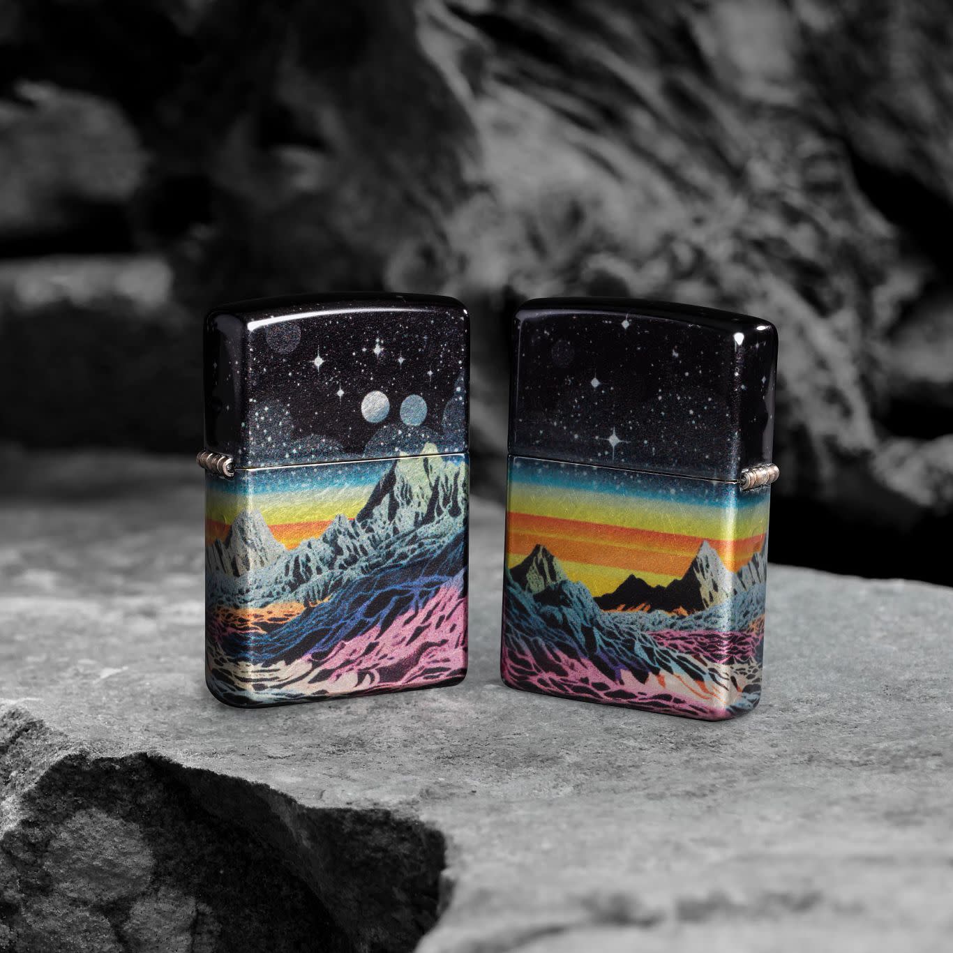 Lifestyle image of two Zippo Space in Color Design 540 Tumbled Chrome Windproof Lighters standing on a rock.