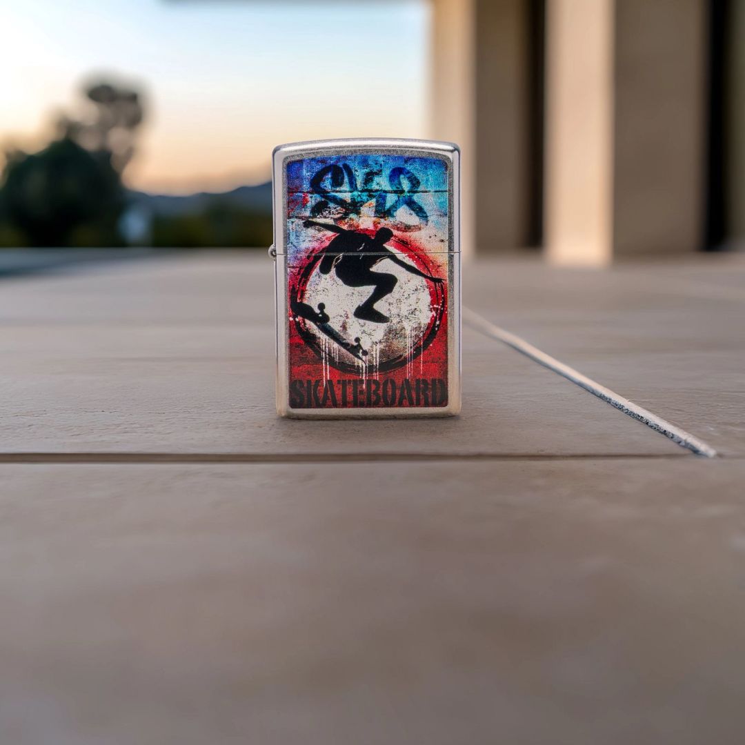 Lifestyle image of Zippo Kickflip Design Street Chrome Windproof Lighter standing on a tile floor showing the front of the lighter with a scenic background. 

